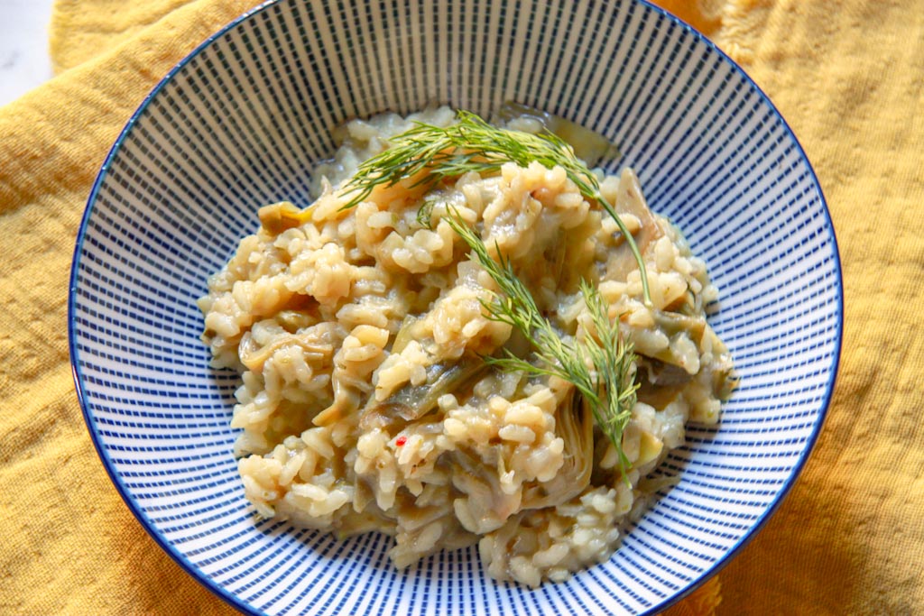 Risotto de alcachofas sencillo y vegetariano sobre un plato.